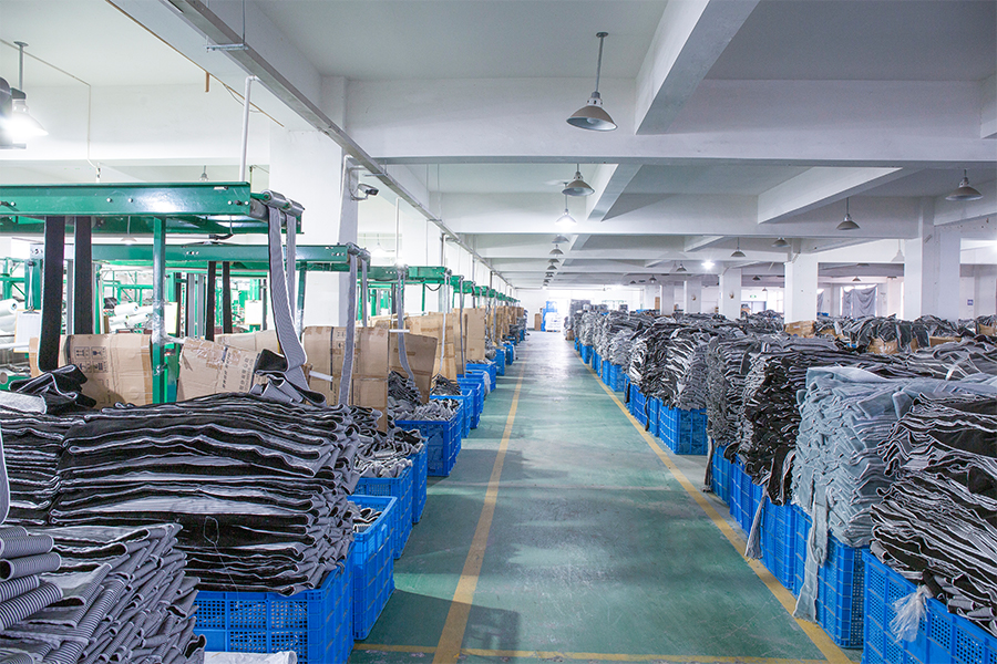 Factory floor with sorted weatherstrip materials and carton stacks